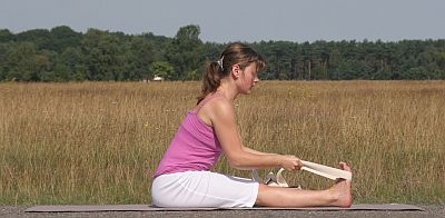 Yogaübung-Paschimottanasana-sitzende-Vorbeuge-mit-Gurt